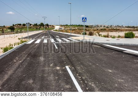 New Road Markings And Road Signs On Freshly Tarmacked Roads On Spanish Urbanisation