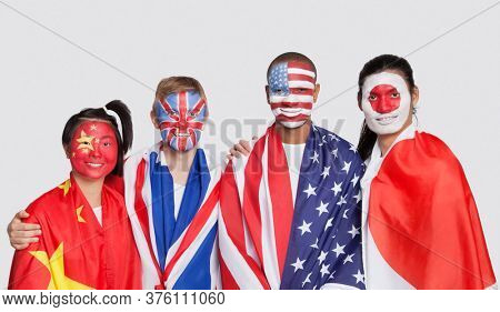 Portrait of multi-ethnic group with national flags and face painting against white background