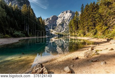 Incredible View On Majestic Famouse Lake Braies During Sunrise. Wonderful Sunny Landscape In Dolomit