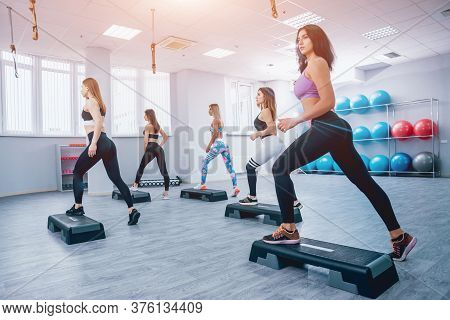 Young Fitness Women Using Step Platform At The Gym.  Training.