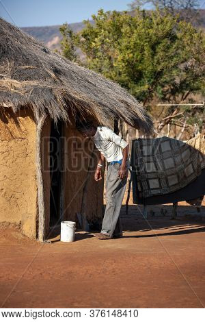 african man villager in his yard walking to his  house in a village in Botswana