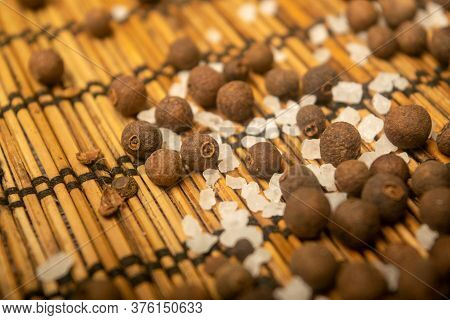 Fragrant Black Pepper And Coarse Sea Salt In Bulk On A Reed Mat. Close Up.