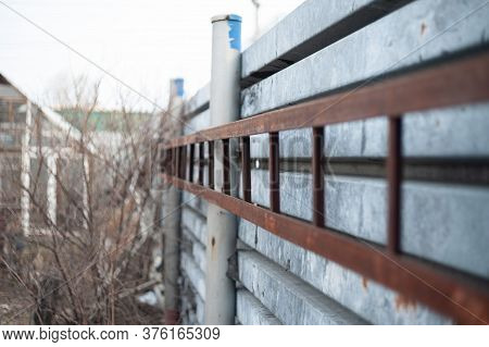 Metal Old Staircase Hanging On A Corrugated Fence