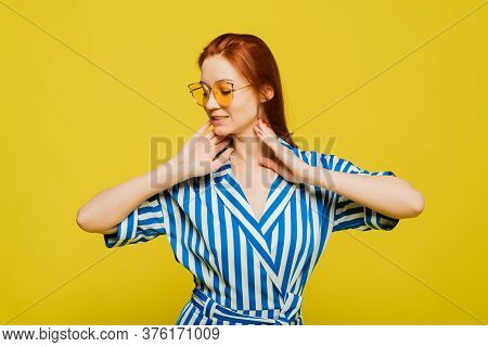 An Attractive Girl With Red Head Is On The Yellow Background. Sexy Girl In Sungasses Is On The Backg