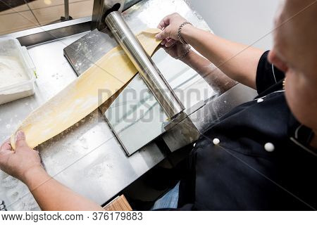 Chef Rolling Dough With A Pasta Machine. Pasta Maker Machine. Hom