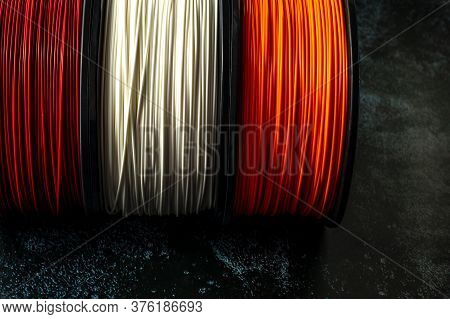 Three Coils Of Filament For 3d Printing. Bright Thermoplastic Of Red, White Smd Orange Colors. Reels