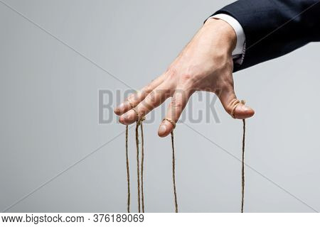 Partial View Of Puppeteer In Suit With Strings On Fingers Isolated On Grey