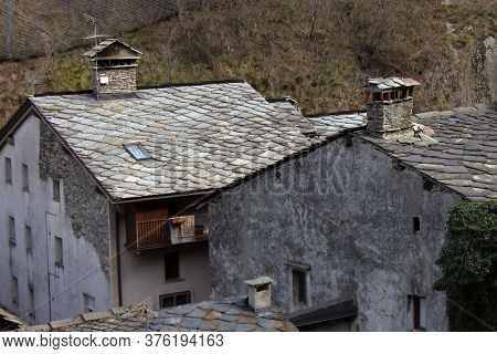 Mountain Cottage With The Typical Roof Of Stone Slabs In Val Daosta, Italy. High Quality Photo