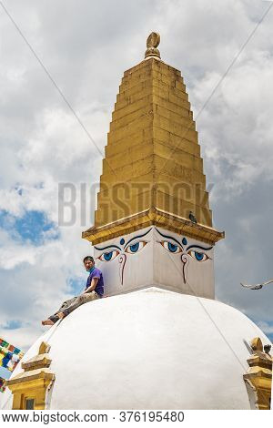 A Man Sit On A White Stupa, With A Brush In His Teeth, Make Of A Break In Time Of Restoration Work O