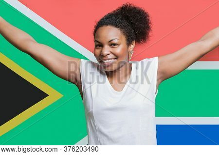Portrait of young African American woman smiling against South African flag