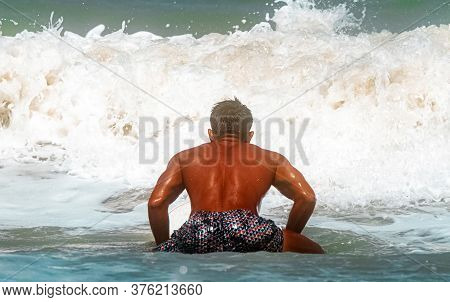 Young Handsome Man Wet All Over Body Holding Surfboard With Right Hand,walking On The Beach,show Fit
