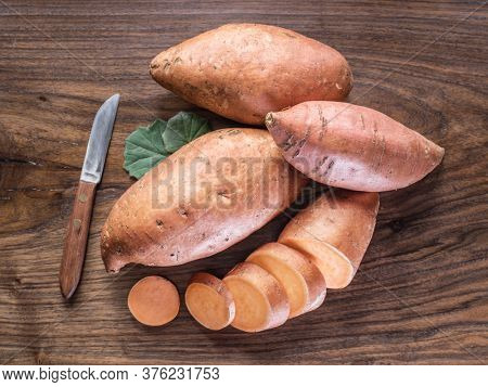 Sweet potatoes on the old wooden table.