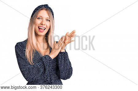 Young beautiful blonde woman wearing casual clothes clapping and applauding happy and joyful, smiling proud hands together 