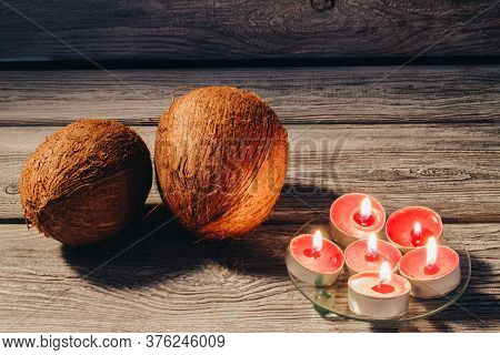 Concept Of Relaxtion And Spa Therapy. Close-up Coconuts And A Bunch Of Small Candles On Wood.