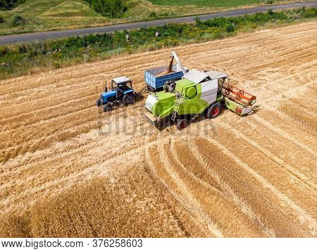 Aerial Drone Top View Big Powerful Industrial Combine Harvester Machine Unloading Bin Of Wheat Cerea