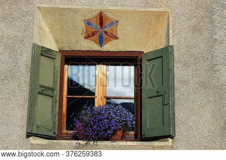 Old Wooden Window On A Wall With A Geometric Decoration. Ancient Village Of Guarda, Scuol Municipali