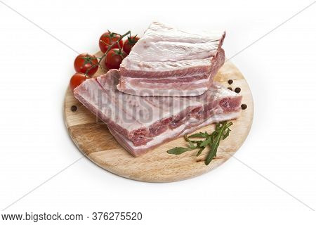 raw ribs on a cutting board isolated on a white background.