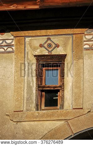 Old Wooden Window On A Wall With Decorations In The Ancient Village Of Guarda, Scuol Municipality, E