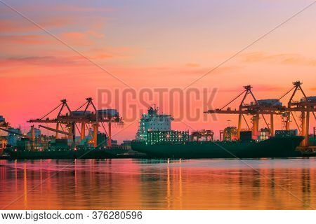 Container Ship At Logistic Port Against Beautiful Sunset Sky