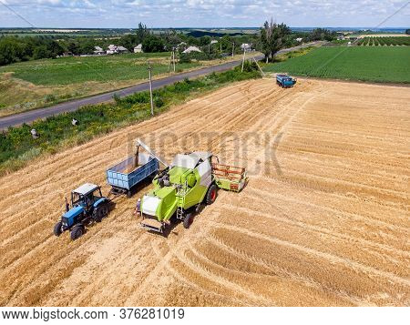 Aerial Drone Top View Big Powerful Industrial Combine Harvester Machine Unloading Bin Of Wheat Cerea