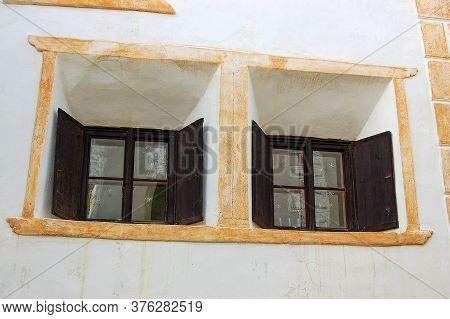 Two Old Windows With Wooden Shutters On A White And Orange Wall In The Ancient Village Of Guarda, Sc