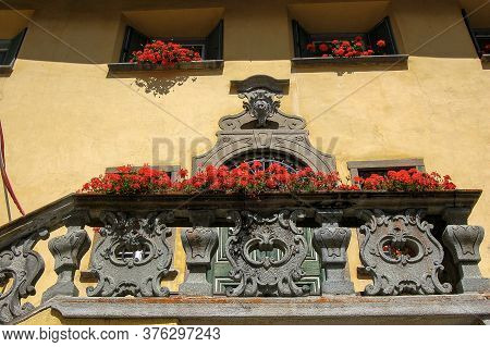 Ancient House With Stone Balcony, Door And Windows With Red Geraniums, Ancient Village Of Zuoz, Tour