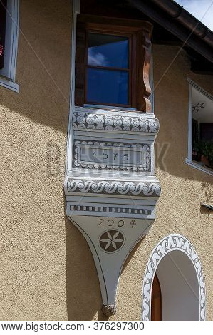 Small Balcony With Wooden Windows In The Ancient Village Of Zuoz, Tourist Resort In Engadin Valley, 