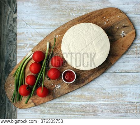 Homemade Cheese Made From Goats Milk, Small Tomatoes On A Branch, Red Sauce Lie On A Wooden Board On
