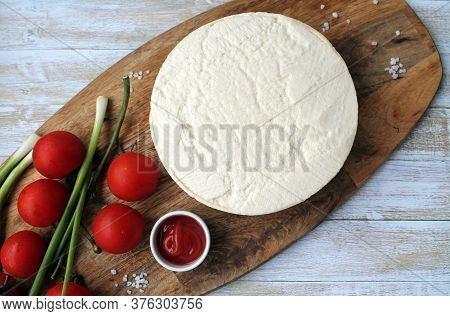 Homemade Cheese Made From Goats Milk, Small Tomatoes On A Branch, Red Sauce Lie On A Wooden Board On