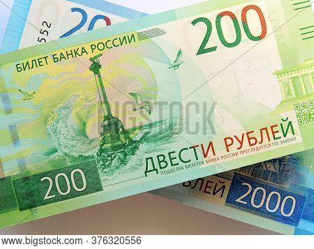 Russian Banknote 200 Rubles Lies On The Banknote 2000 Rubles. The Bill Depicts A Monument To The Scu