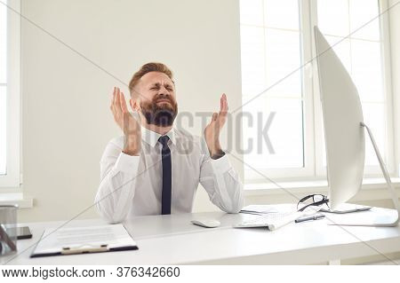 Upset Tired Businessman Raised His Hands Up Looking At A Computer At A Desk In The Office.