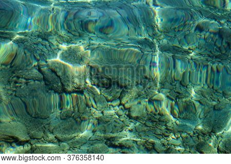 Top View Of Blue, Green And Turquoise Colors Of Water, Surface Of Sea On Rocks And Bottom. Reflectio