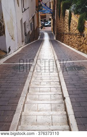 Polop De Marina, Costa Blanca, Spain - 3 Otober 2019: Narrow Alley With Two Tracks For Car Wheels An