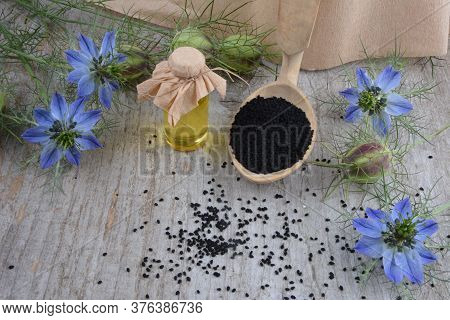 Black Cumin (nigella Sativa Or Kalonji) Seeds In Heart-shaped Bowl On Wooden Background