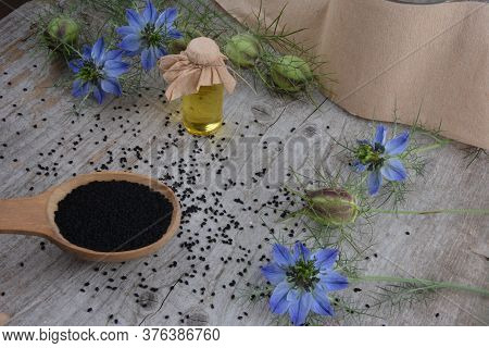 Black Cumin (nigella Sativa Or Kalonji) Seeds In Heart-shaped Bowl On Wooden Background