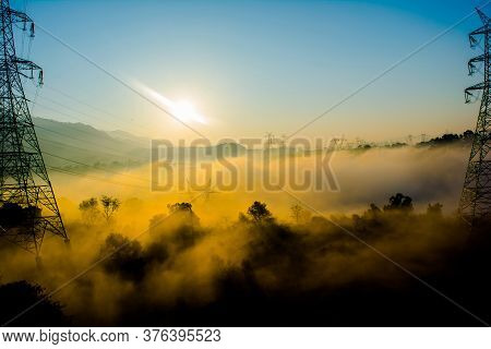 Sun Rays Coming Through The Trees And Electric Towers With Fog Enhancing The Light At Sunrise, Aeria