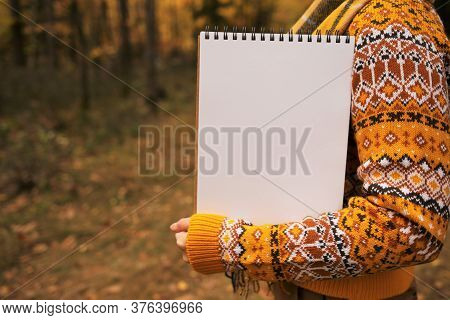 Autumn Mock Up. Autumn To-do List.back To School.girl In A Brown Sweater Holds A Blank Notebook On A
