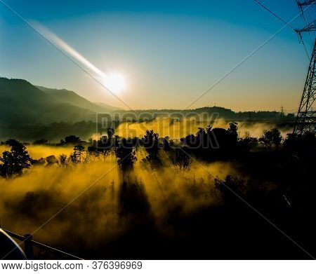 Sun Rays Coming Through The Trees And Electric Towers With Fog Enhancing The Light At Sunrise, Aeria