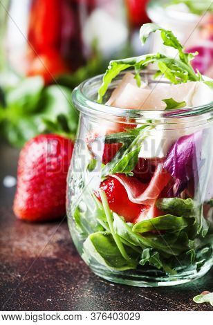Fresh Salad With Spicy Arugula, Goat Cheese, Strawberry And Prosciutto Or Ham In Modern Glass Jars O
