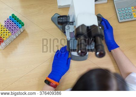 Laboratory Assistant Is Looking Through A Microscope. Close-up Doctor Laboratory Assistant Looking T