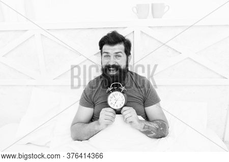 Happy Wake Up Of Man Lying In Bed With Alarm Clock. Guy Is Waking Up. Alarm Clock In The Morning. Ma