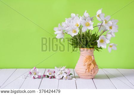 Bouquet Of White Wildflowers In A Vase On A Light Green Background. Anemone Sylvestris