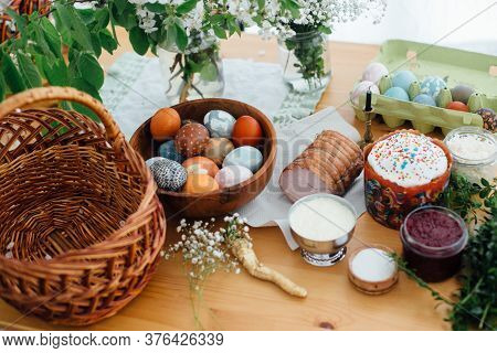 Easter Modern Eggs, Easter Bread, Ham, Beets, Butter, Green Branches  And Flowers On Rustic Wooden T