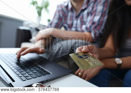 Close-up Of Happy Couple Shopping Online Using Plastic Credit Card. Man Searching For Something On L