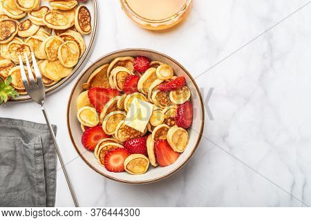 Trendy Home Breakfast With Tiny Cereal Pancakes With Piece Of Butter And Fresh Strawberries In The B
