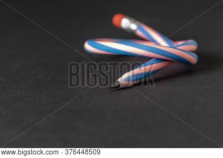 Flexible Pencil On A Dark Background. Selective Focus