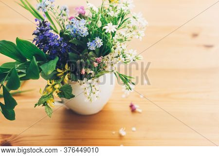 Wildflowers Bouquet In Old Cup On Wooden Table,  Space For Text. Blooming Spring Flowers In Soft Lig