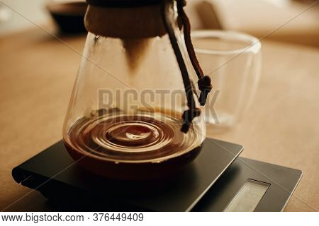 Drip Coffee. Coffee Drops Closeup From Filter In Glass Kettle On Scale. Brewing Aromatic Fresh Alter