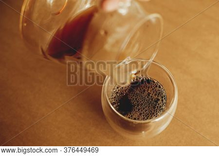 Brewing Alternative Coffee, V60. Pouring Fresh Aromatic Coffee From Glass Kettle In Cup On Brown Bac