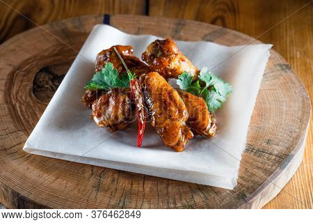 Appetizing Fried Chicken Wings In Sauce On A Wooden Tray. The Concept Of Food And Serving, Food In B